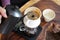 Barista pouring hot water over coffee grounds making drip brew coffee.