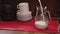 Barista pouring milk into a glass jug. Medium shot