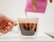 Barista pouring steamed milk into coffee cup. A milk jug and a cup of coffee, makes cappuccino, pouring whipped milk