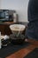 Barista preparing coffee pour over coffee maker and drip kettle.