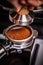 Barista presses ground coffee