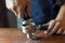 Barista presses ground coffee using tamper, prepares espresso in his coffee shop