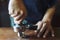 Barista presses ground coffee using tamper, prepares espresso in his coffee shop