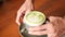 Barista Puts a Cup of Matcha Green Tea on Wooden Table in Coffee Shop. 4K, Slowmotion.