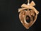 Bark wooden heart on a rope with little opaque brass bell in the