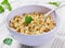 Barley porridge in a bowl with meat, vegetables and green parsley