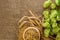 Barley raw grain in wooden bowl, wheat ears and hops green cones on burlap background with copy space, flat lay