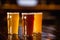 Barley, unfiltered, light beer in glasses on wooden table in blurry interior