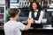 Barmaid serving drink to man