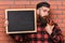 Barman with beard and pensive face drinks cocktail