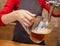 Barman hands at beer tap pouring a draught lager beer serving in a restaurant or pub