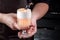 Barman holding a glass with cocktail with white foam, decorated with a small plum