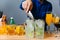 Barman making a cocktail with lime, orange, lemon and ice