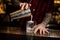 Barman pouring fresh creamy alcoholic drink into a glass