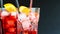 Barman pouring red spritz aperitif aperol cocktail with two orange slices and ice cubes on black