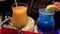 Barman preparing two colorful exotic cocktails in night club