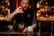 Barman stirring a delicious brown cocktail with a steel spoon in the measuring glass cup