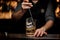 Barman stirring a delicious cocktail with a steel spoon in the measuring glass cup