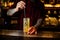 Barman stirring fresh alcoholic cocktail with cucumber and gin