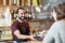 Barman and woman with card reader and smartphone