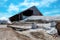 Barn with brine salt in sack. Pile of organic sea salt and bamboo basket in front of barn with blue sky and white clouds in summer