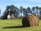 Barn in field with hay in foreground