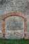 Barn gate door fake false faux arch, stone wall background frame closeup, vertical limestone copy space, green grass