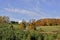 A barn house in the hilltop surrounded by autumn leaf colors