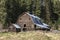 Barn nestled by pine trees.