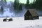 Barn and old wooden wagon in the snow