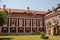 Baroque castle Steknik, stucco, peeling dark red plaster, red tile roof, green lawn, italian garden, aristocratic residence in