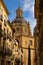 Baroque dome of La Clerecia dominating narrow street of Salamanca