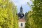 Baroque monastery through green trees