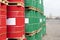 Barrels of 200 liters of metal are in the pallet on the street. Red and green barrels for petroleum, chemicals, gasoline.