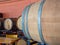 Barrels lining the corner of a winery or brewery with dining tables