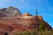 A Barren Tree Stands Against A Colorful Sandstone Mountain