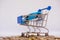 A barrow small shopping cart with coins on a white background for economizing  buying cars Concept of economizing and buying cars