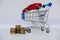 A barrow small shopping cart with coins on a white background for economizing  buying cars Concept of economizing and buying cars