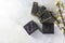 Bars of handmade organic soap with charcoal on a light background. Blackcurrant sorbet