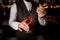 bartender accurate holds glass of drink and decorates it with wheat spikelet