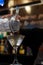 Bartender at a bar counter preparing a martini in a glass. Close-up of a martini drink being prepared by the waiter