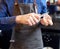 Bartender grinding ice cube with knife at bar