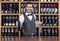 Bartender Holding Red Wine Bottle And Glass In Shop