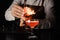 The bartender makes flame above cocktail