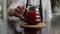 Bartender makes tea. Waiter hand holding cup with tea in the bar. a waiter is putting hot pad on the table and putting