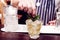 Bartender is making cocktail at bar counter, toned