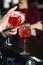 Bartender making refreshing pink coctail with a rose on top