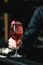 bartender making refreshing pink coctail with a rose on top isolated on a bar background