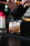 Bartender making relaxing cocktail on a bar background