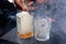 The bartender mixes whiskey with smoke to give a special taste to the drink